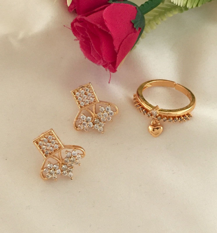 Gold earrings with intricate designs and a matching gold ring adorned with a small heart charm.