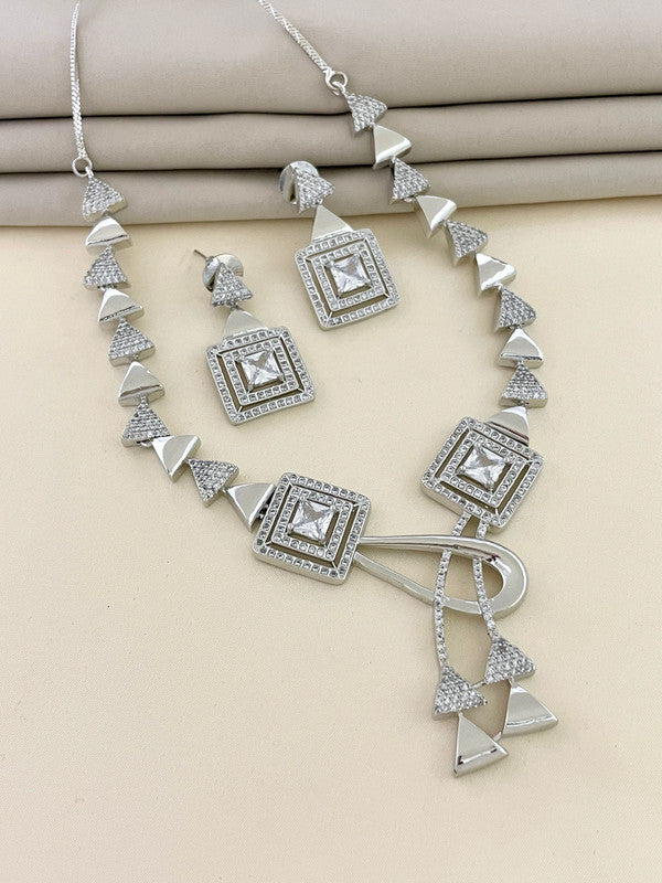 A silver necklace and earring set with geometric designs and embedded stones.