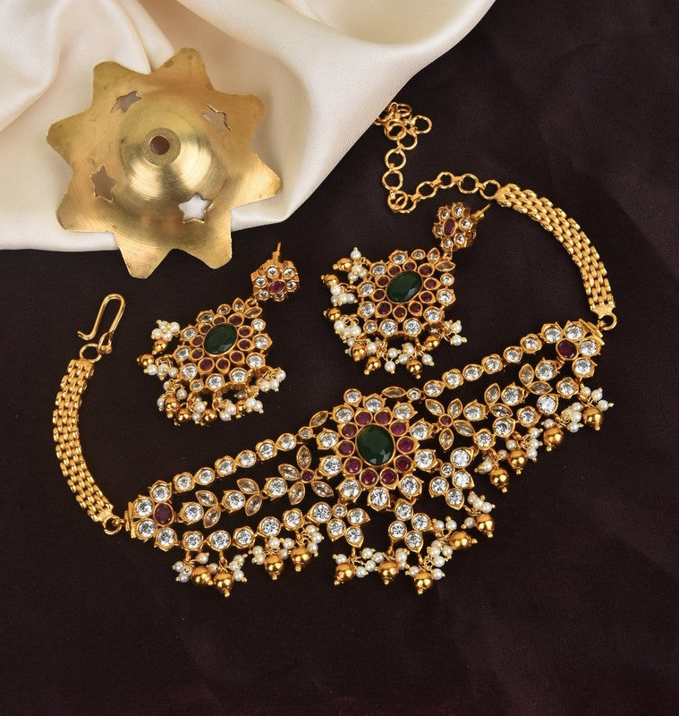 Gold and gemstone jewelry set with a necklace and matching earrings.