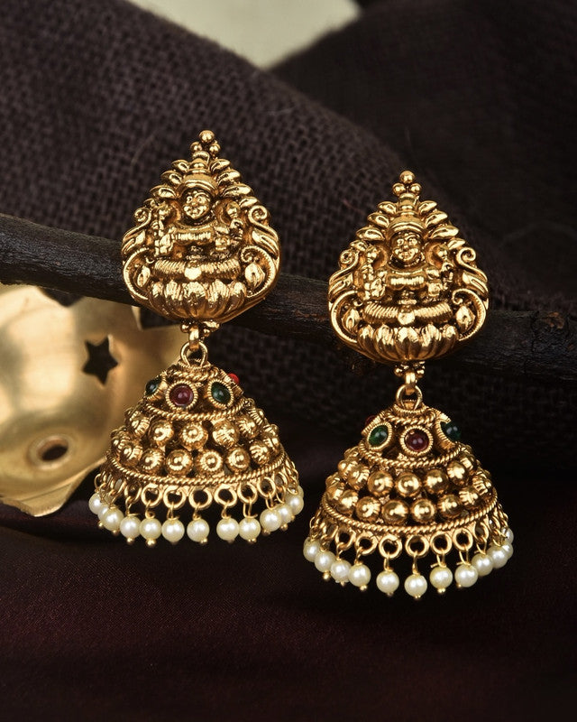 Gold temple-style jhumka earrings with intricate designs, adorned with small pearls and colored stones.