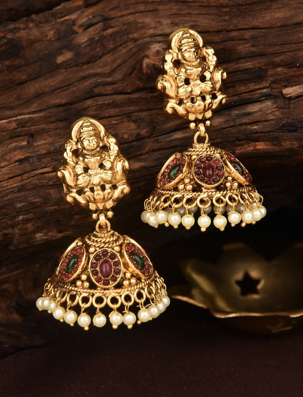 Gold jhumka earrings with intricate designs, featuring red and green gemstones and pearl accents.