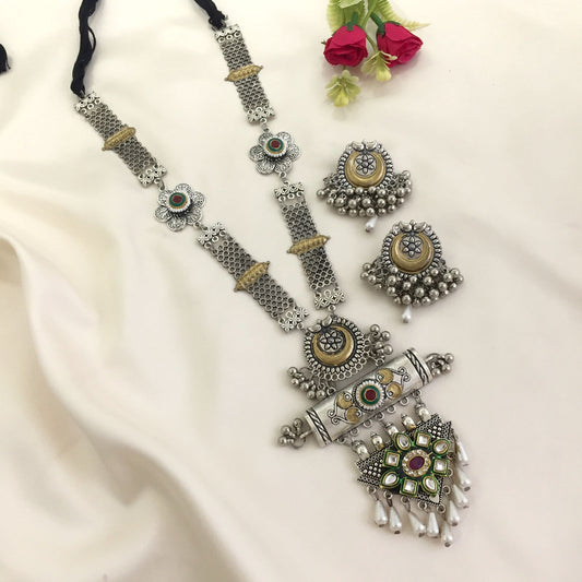 A set of traditional silver jewelry consisting of a long necklace with intricate designs and colorful stones, accompanied by a pair of matching earrings.