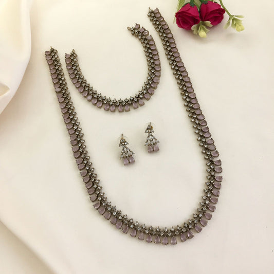 A set of jewelry consisting of a necklace, a bracelet, and a pair of earrings, all featuring purple gemstones and intricate silver detailing.