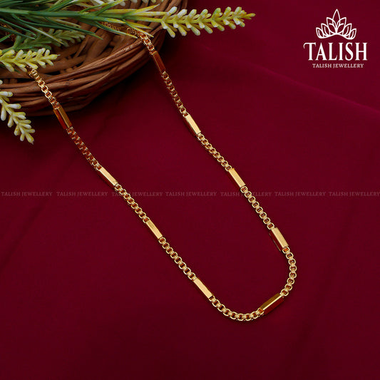 A gold chain necklace with a combination of smooth and textured links, displayed on a red fabric background with a decorative plant in the corner. The brand name "Talish Jewellery" is visible.