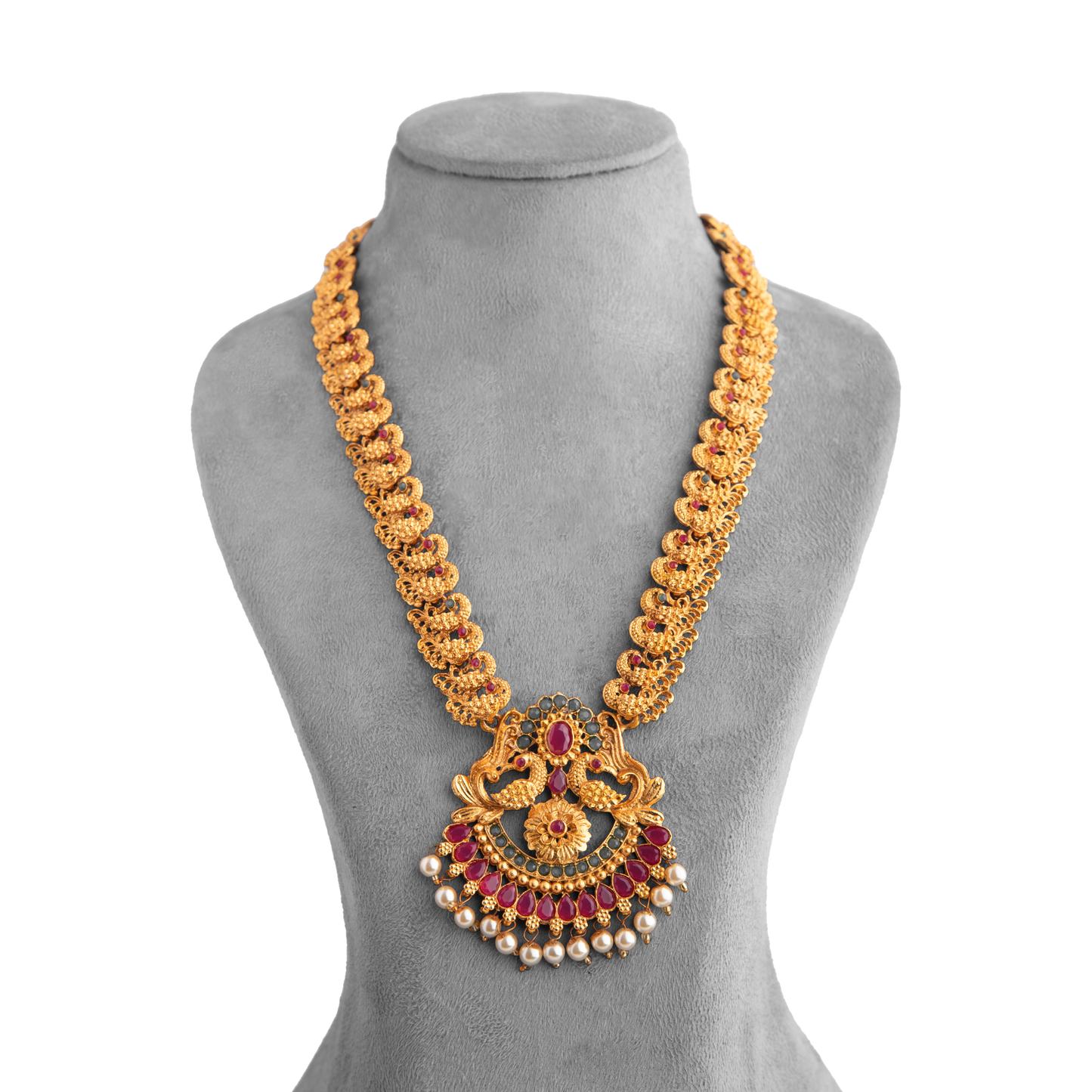 Gold necklace with intricate design, featuring red gemstones and pearl accents, displayed on a grey mannequin bust.