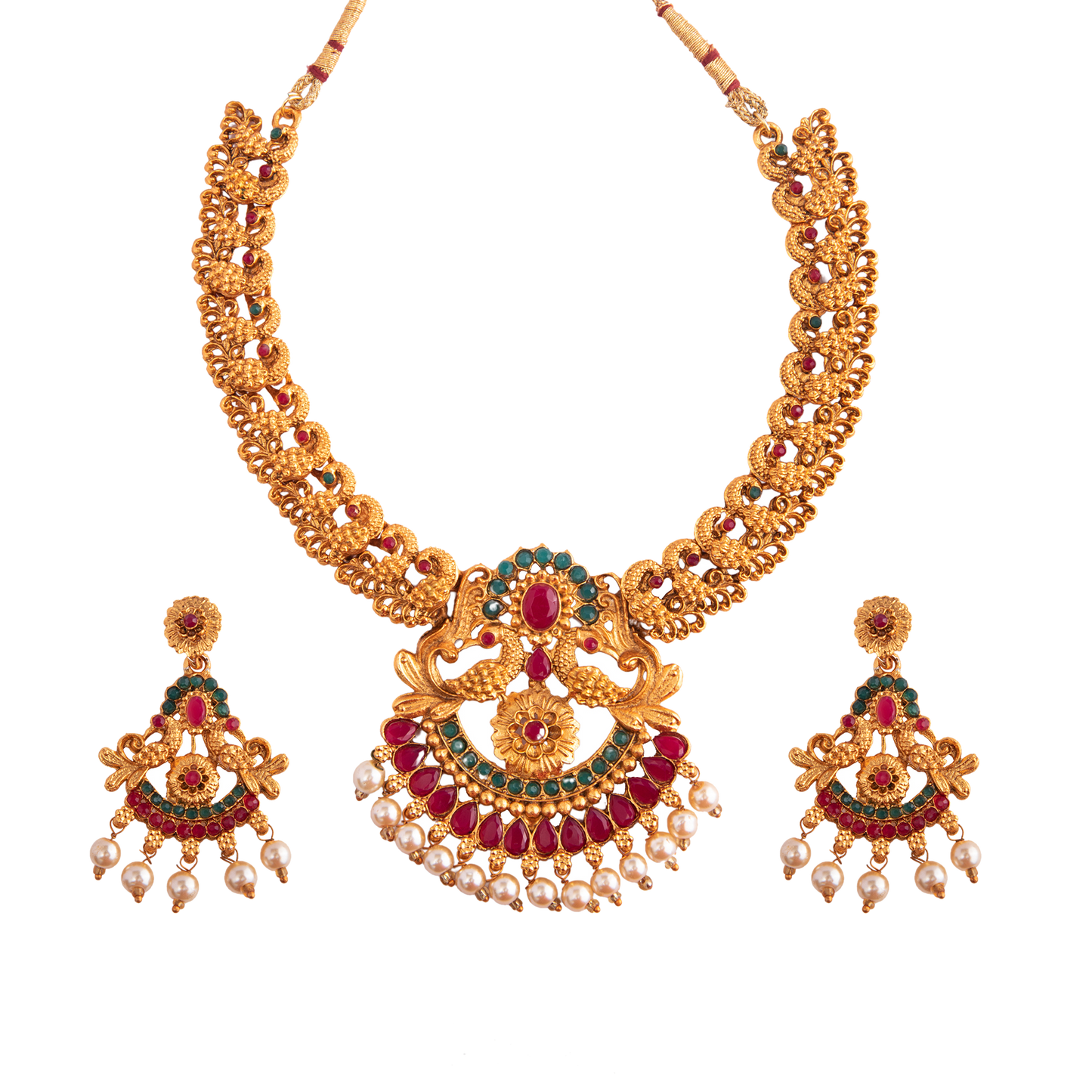 A gold necklace set with intricate designs, featuring red and green gemstones, and matching earrings adorned with pearl drops.