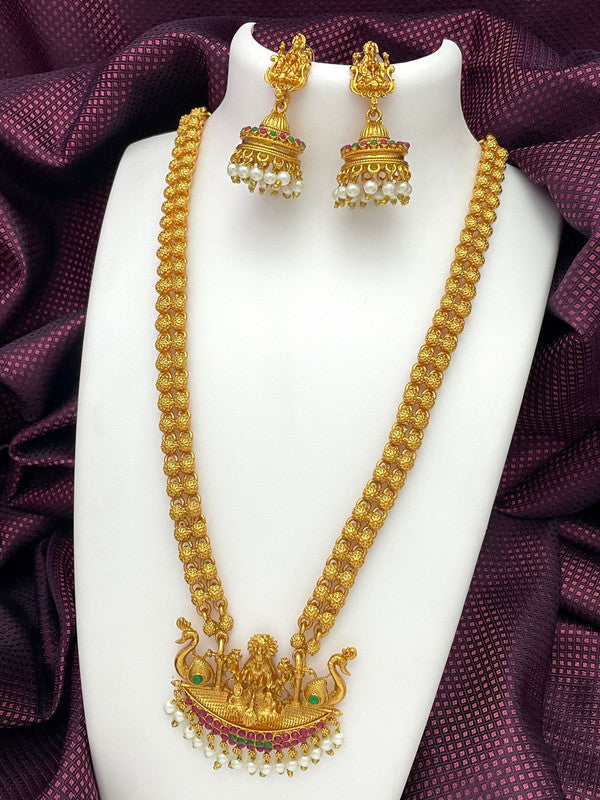 Gold necklace with intricate design and matching earrings displayed on a white stand.