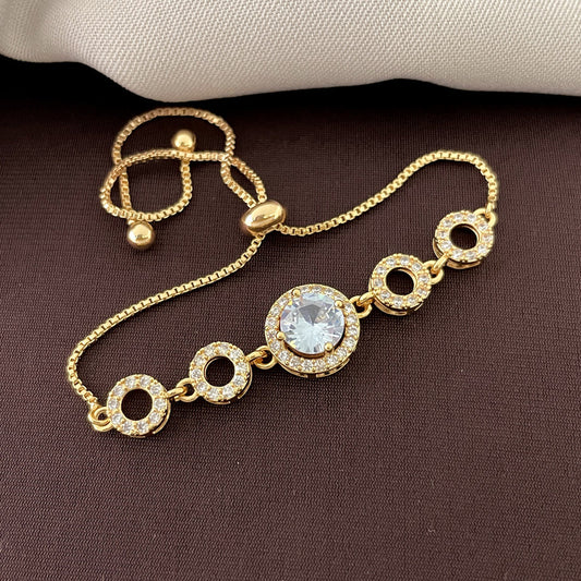 A gold bracelet with a central large round gemstone and four smaller circular links, each encrusted with smaller gemstones.