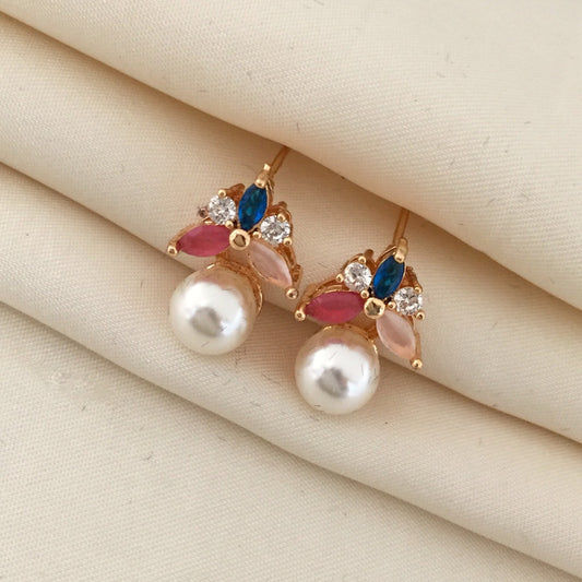 Gold earrings with pearl drops, adorned with blue, pink, and clear gemstones.