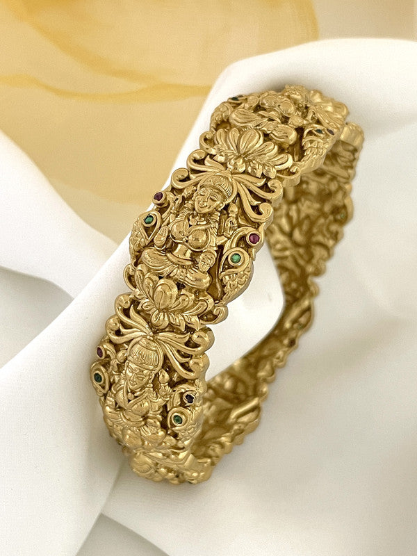 Ornate gold bracelet with intricate designs and embedded gemstones.