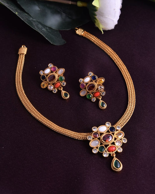 A gold necklace and matching earrings set adorned with multicolored gemstones.