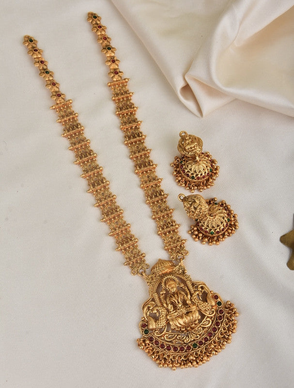 A gold necklace set featuring an intricately designed pendant with a deity figure, accompanied by matching earrings.