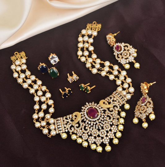 A set of gold and pearl jewelry including a necklace, earrings, and rings with intricate designs and gemstone accents.