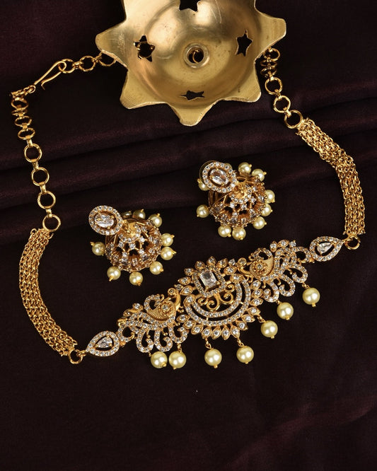 Gold necklace and earrings set with intricate designs and pearl accents.