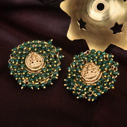 Gold and green beaded earrings with intricate lion face design.