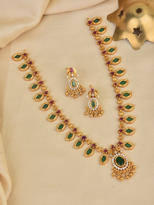 A gold necklace set with green and red gemstones, accompanied by matching earrings.