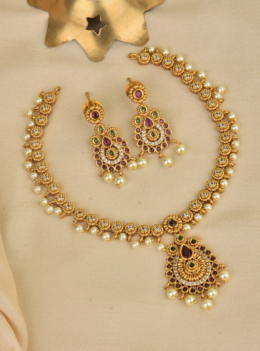 A set of traditional gold jewelry featuring a necklace and matching earrings adorned with pearls and colorful gemstones.