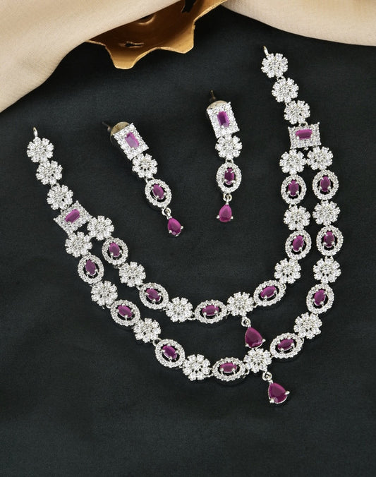 A set of jewelry consisting of a necklace and matching earrings. The pieces feature intricate designs with silver and purple gemstones.