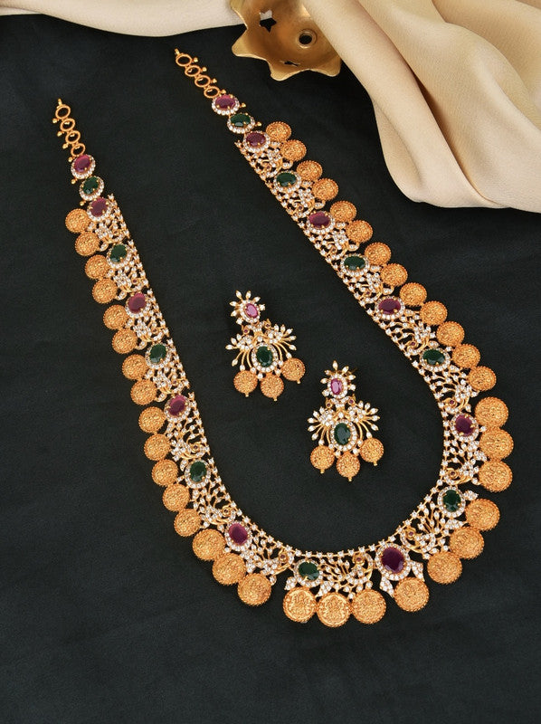 A gold necklace and matching earrings set adorned with green and purple gemstones.