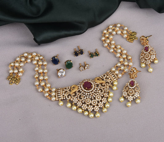 A set of traditional jewelry including a pearl and gold necklace with intricate designs, matching earrings, and various stud earrings in different colors.