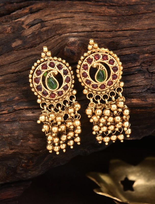 Gold earrings with intricate circular designs, featuring green and red gemstones, and multiple dangling gold beads.