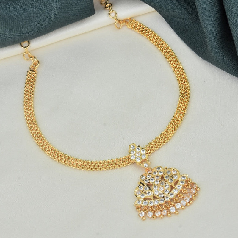 A gold necklace with a pendant featuring intricate designs and embedded with white stones.