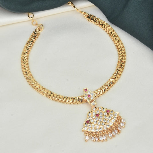 A gold necklace with a decorative pendant featuring multiple small gemstones.