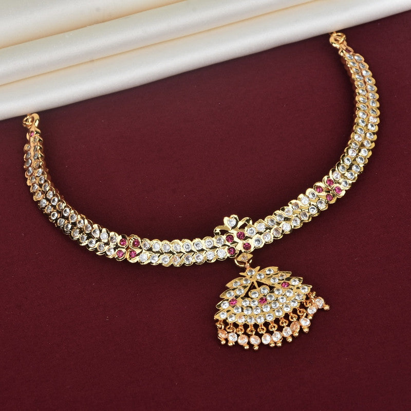 Gold necklace with intricate design and gemstone embellishments, featuring a large, ornate pendant.