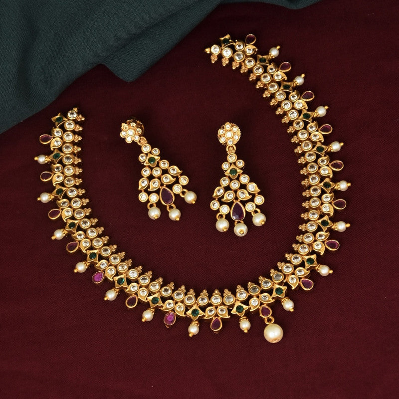 A traditional gold necklace set with matching earrings, featuring intricate designs with pearls and gemstones.
