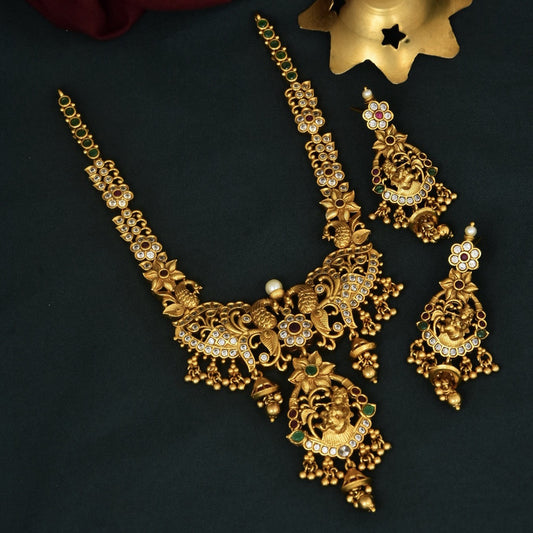 A set of intricately designed gold jewelry featuring a necklace and matching earrings adorned with detailed patterns and embellishments.