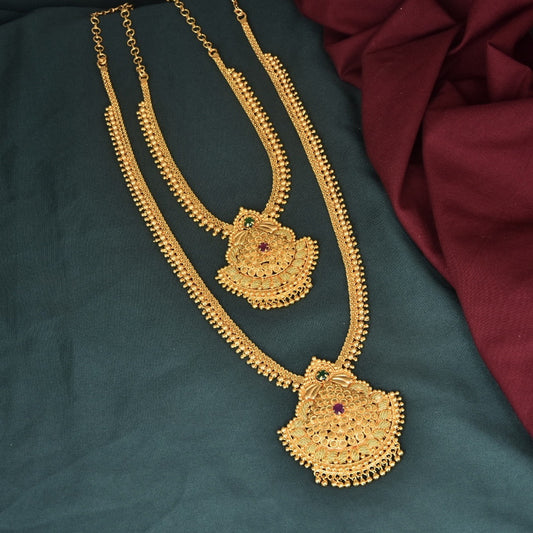 Two gold necklaces with intricate designs and gemstone accents.