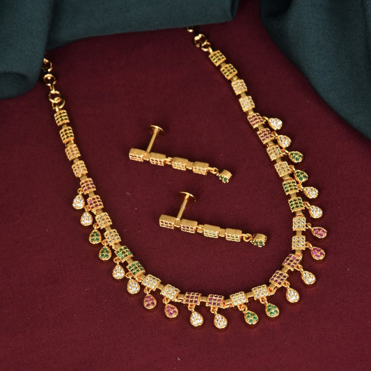 A gold necklace with a geometric design, adorned with multicolored gemstones, and a matching pair of earrings.