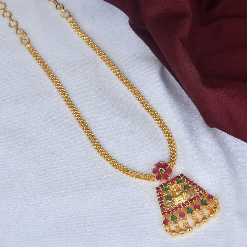 A gold necklace with a pendant featuring red and green gemstones.